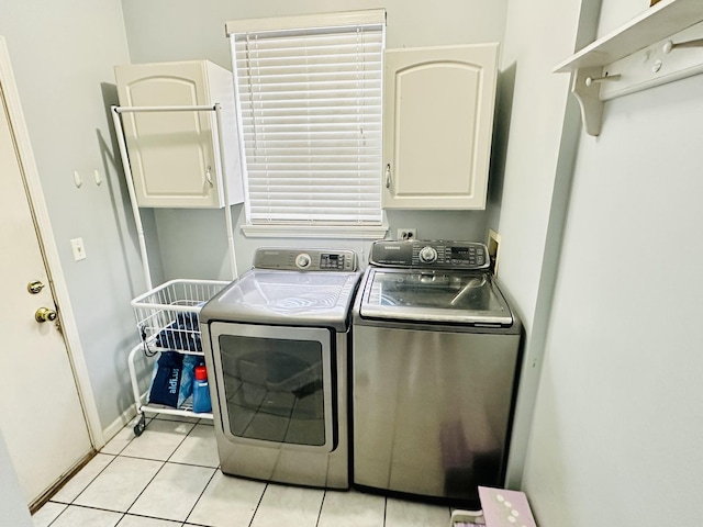 washroom featuring separate washer and dryer, light tile patterned floors, and cabinets