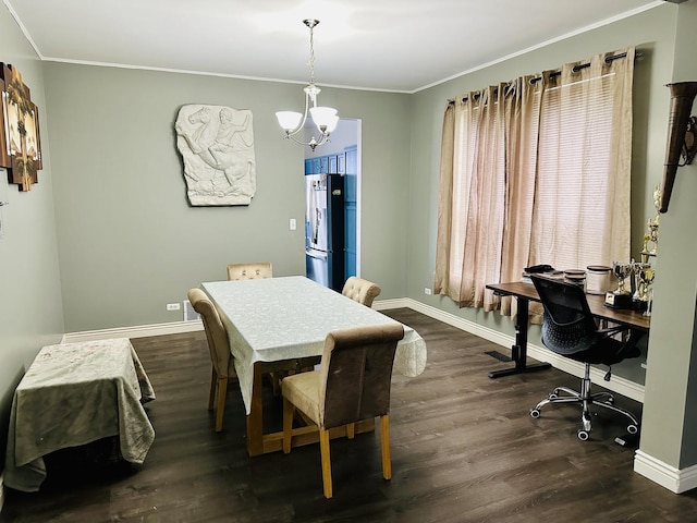 dining space featuring dark hardwood / wood-style flooring, crown molding, and a chandelier