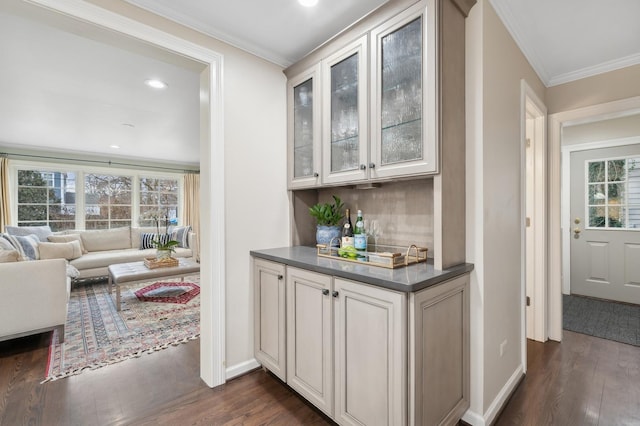 bar featuring white cabinetry, ornamental molding, and dark hardwood / wood-style floors