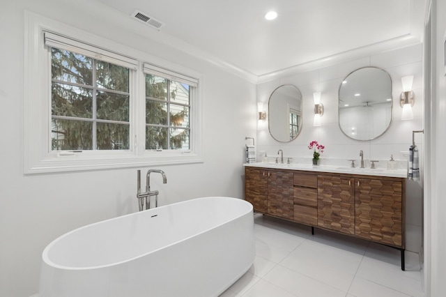 bathroom featuring crown molding, tile patterned floors, a tub to relax in, and vanity