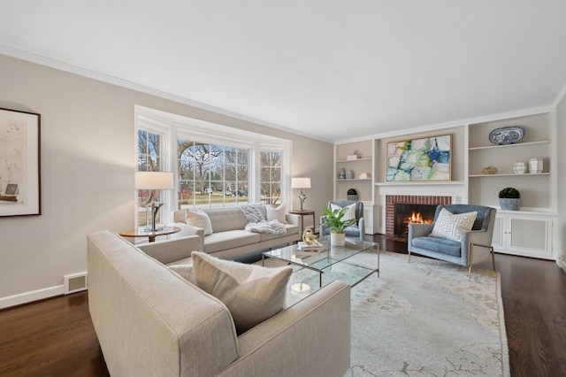 living room featuring dark wood-type flooring, crown molding, and a brick fireplace