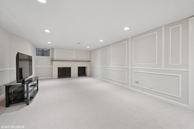 unfurnished living room featuring a brick fireplace and light colored carpet