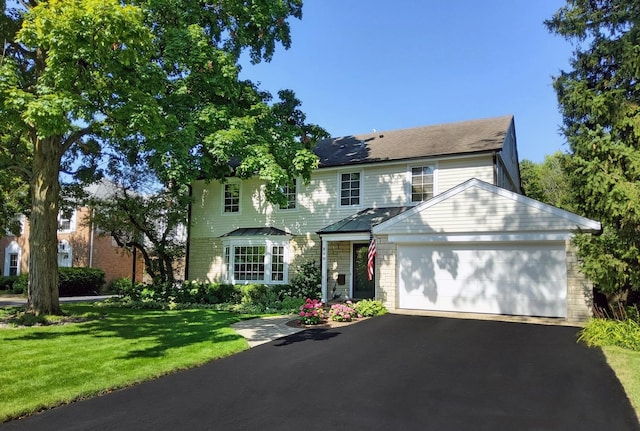 view of front of home with a garage and a front lawn