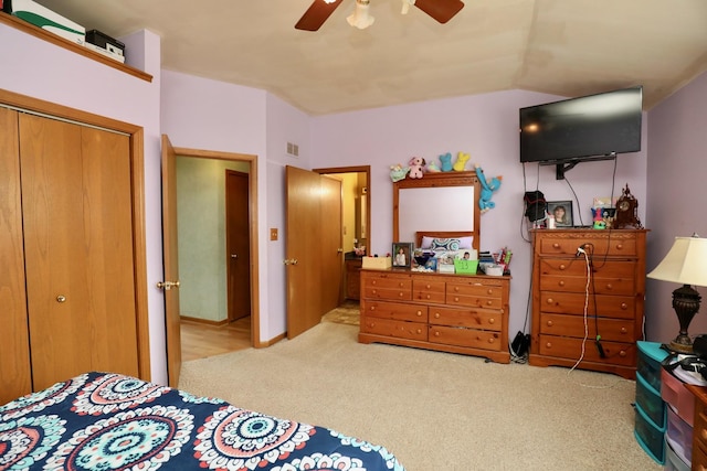 carpeted bedroom with ceiling fan, vaulted ceiling, and a closet