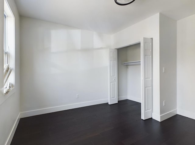 unfurnished bedroom featuring dark wood-type flooring and a closet