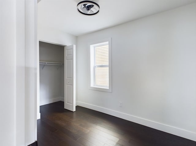 unfurnished bedroom with dark hardwood / wood-style floors and a closet