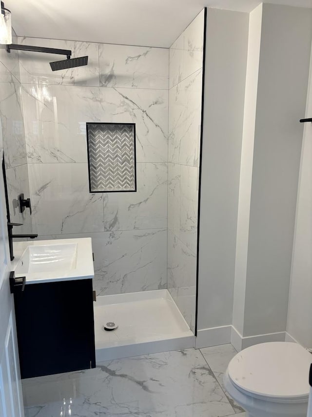 bathroom featuring vanity, tiled shower, and toilet