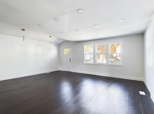 unfurnished room with dark hardwood / wood-style flooring and lofted ceiling