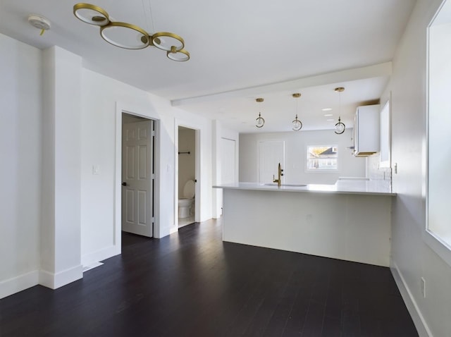 unfurnished living room featuring dark hardwood / wood-style floors and sink