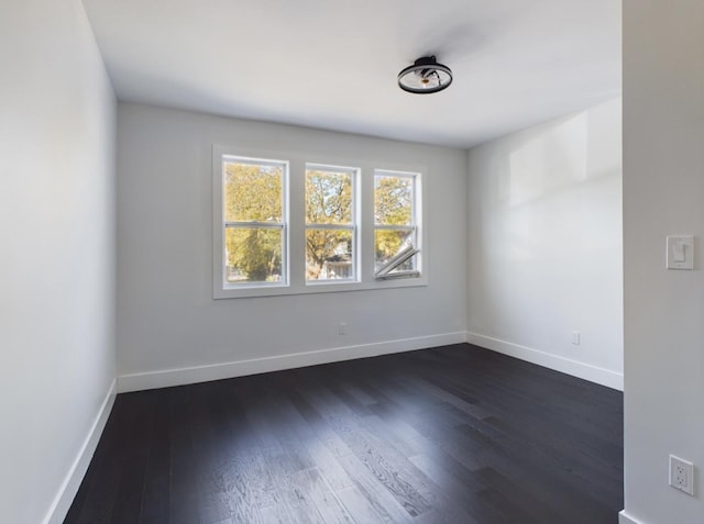 unfurnished room with dark hardwood / wood-style flooring