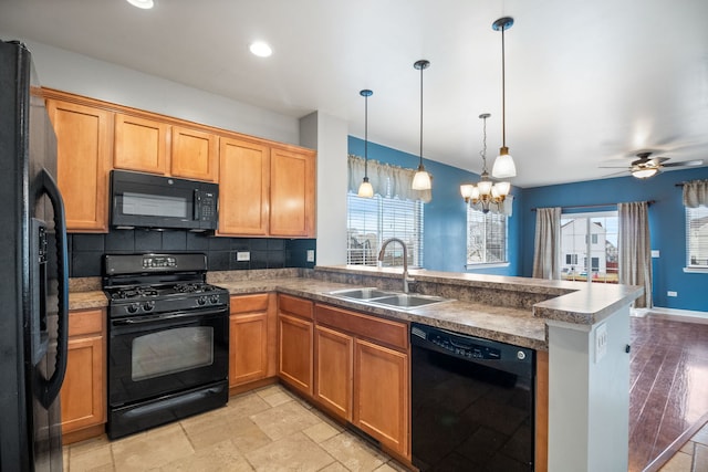 kitchen with sink, backsplash, hanging light fixtures, black appliances, and kitchen peninsula