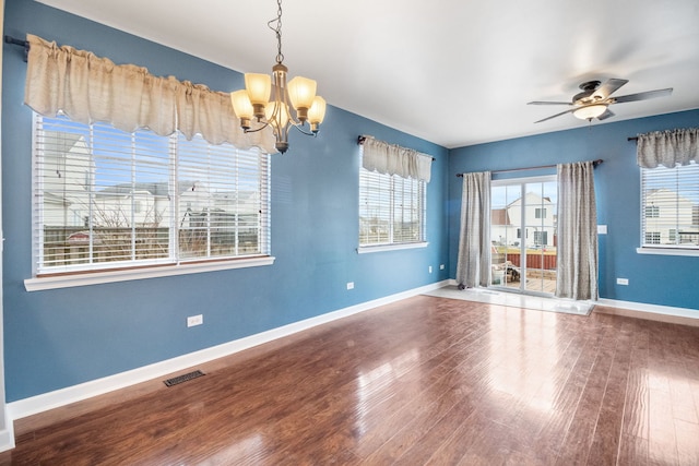 spare room with wood-type flooring and ceiling fan with notable chandelier