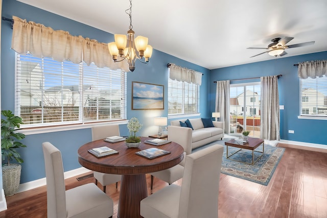 dining space featuring hardwood / wood-style flooring and ceiling fan with notable chandelier