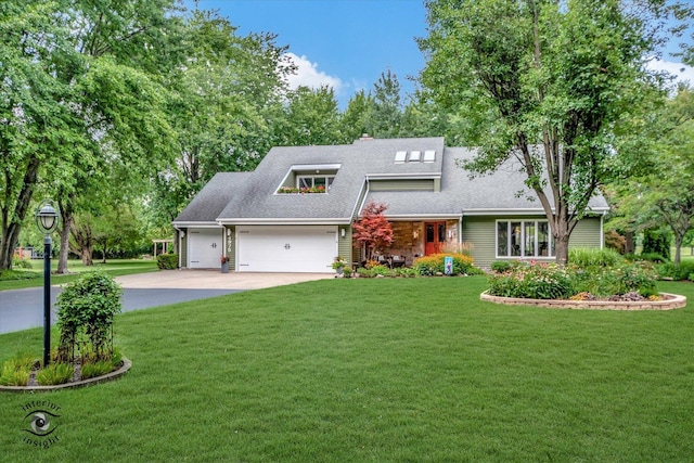 view of front of property featuring roof with shingles, a chimney, an attached garage, a front yard, and driveway