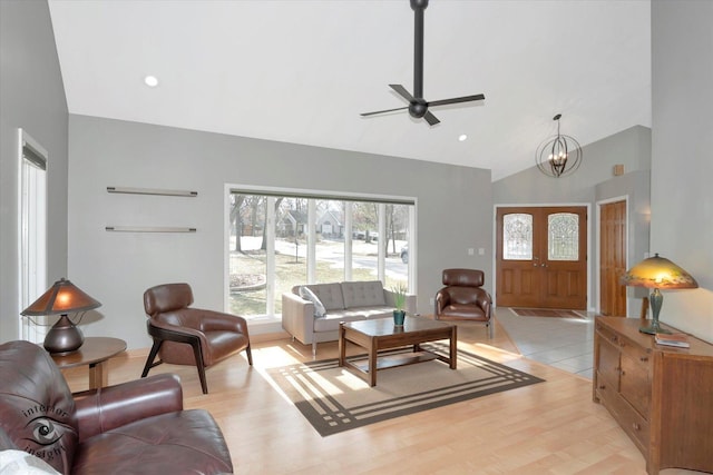 living area with high vaulted ceiling, light wood-style flooring, a chandelier, and recessed lighting