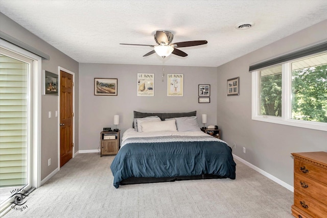 bedroom with baseboards, visible vents, a textured ceiling, and light colored carpet