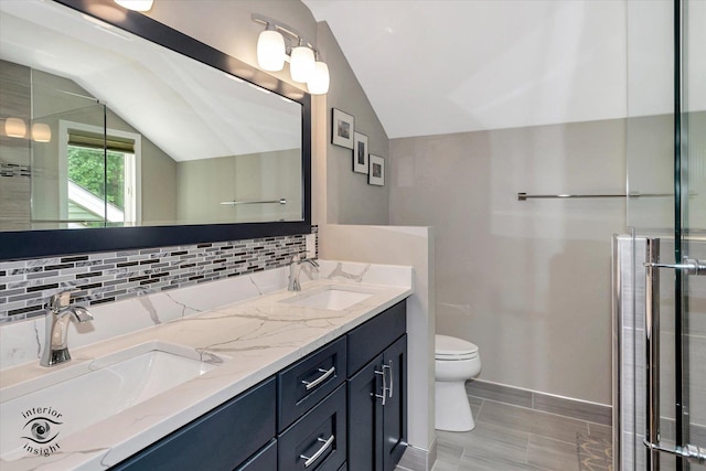 bathroom featuring lofted ceiling, tasteful backsplash, toilet, and a sink