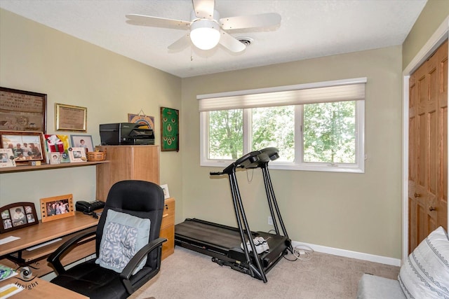 office area featuring ceiling fan, baseboards, and light colored carpet