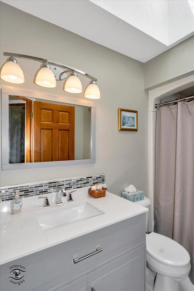 bathroom with toilet, tasteful backsplash, and vanity