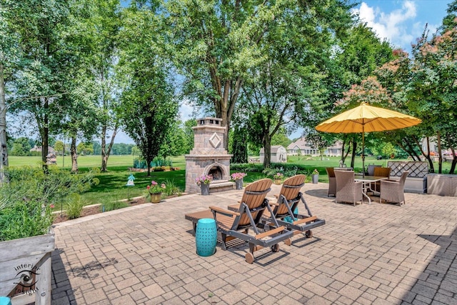 view of patio featuring outdoor dining space and an outdoor stone fireplace