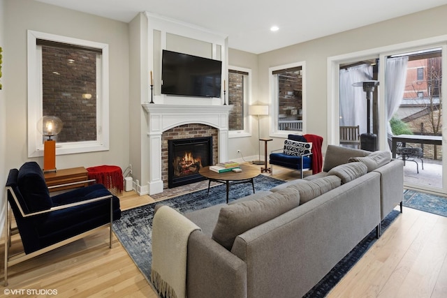 living room featuring hardwood / wood-style floors and a brick fireplace