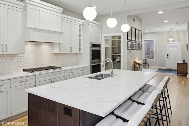 kitchen featuring stainless steel appliances, an island with sink, and sink