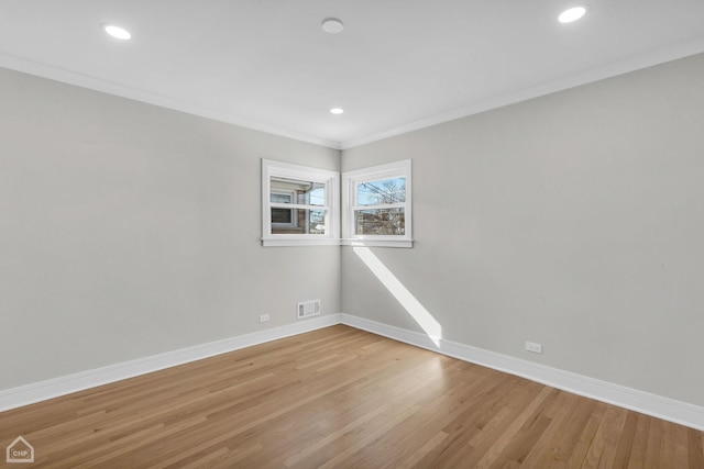 empty room featuring light wood finished floors, visible vents, baseboards, crown molding, and recessed lighting