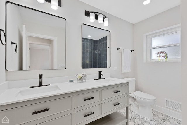 full bath featuring double vanity, visible vents, toilet, and a sink