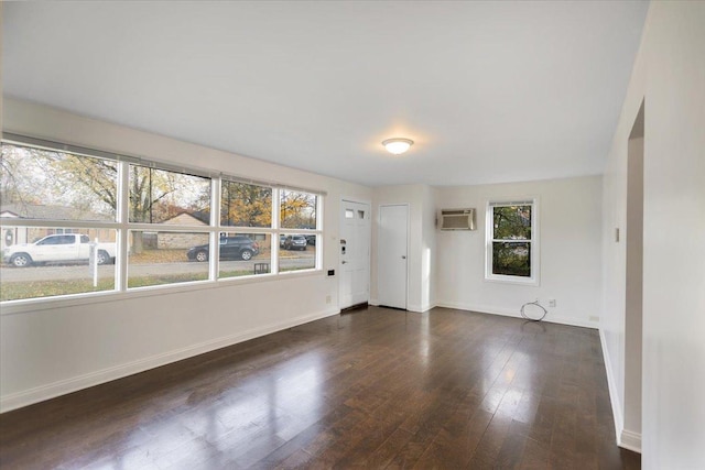 unfurnished room featuring dark wood-type flooring and an AC wall unit