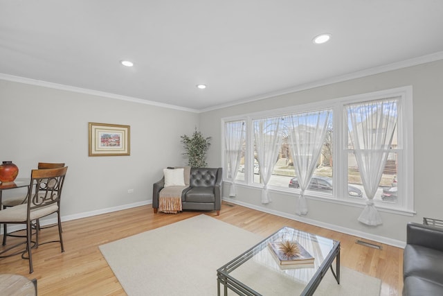 living room with ornamental molding and light hardwood / wood-style floors