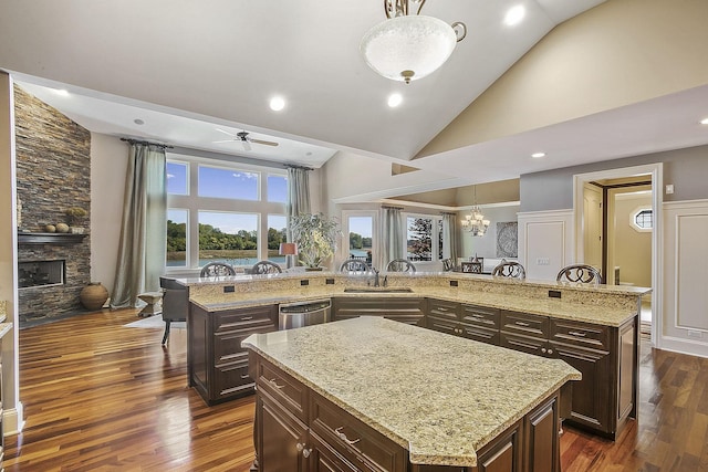 kitchen with a large island, decorative light fixtures, and a stone fireplace