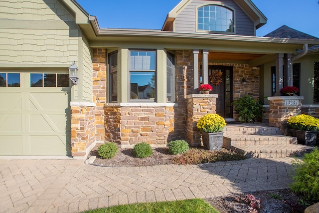 view of exterior entry with a porch and a garage