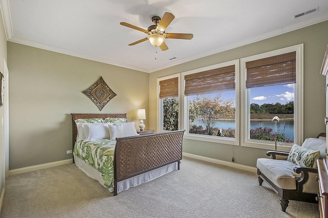 bedroom featuring ornamental molding, light colored carpet, ceiling fan, and a water view