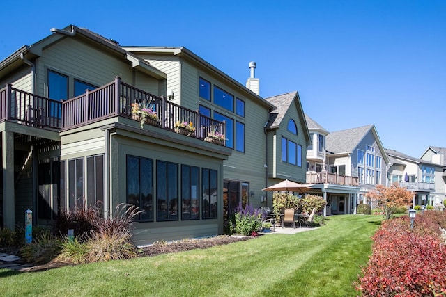 back of property with a patio and a lawn