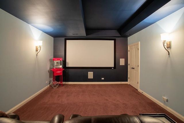 home theater room with a tray ceiling and carpet floors