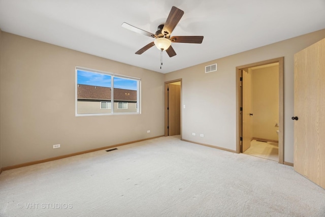 unfurnished bedroom featuring ensuite bathroom, light carpet, and ceiling fan