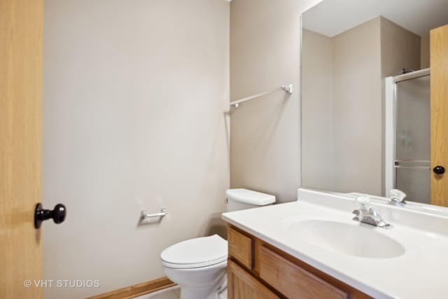 bathroom with walk in shower, vanity, and toilet