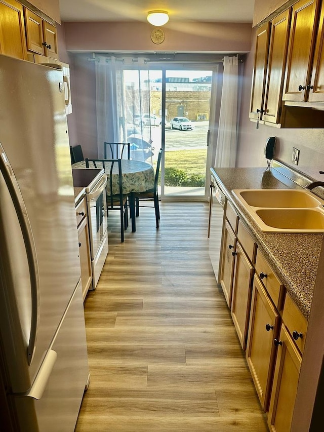500 W Huntington Commons Rd Unit 152, Mount Prospect, IL 60056 - kitchen with freestanding refrigerator, white range with electric stovetop, a sink, dishwashing machine, and brown cabinetry
