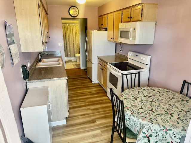 kitchen with sink, white appliances, and light hardwood / wood-style floors