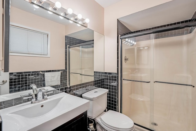 bathroom with walk in shower, vanity, toilet, and tile walls