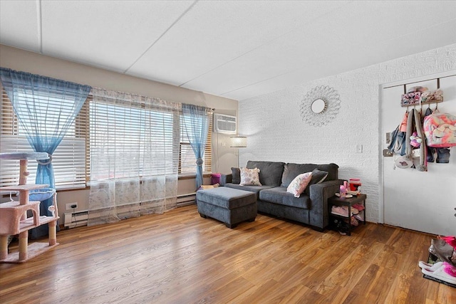 living room with wood-type flooring, an AC wall unit, and a baseboard radiator