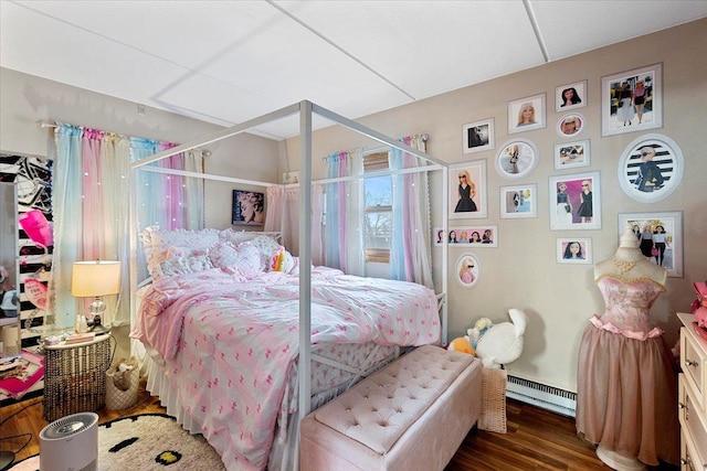 bedroom with a baseboard radiator and dark hardwood / wood-style floors