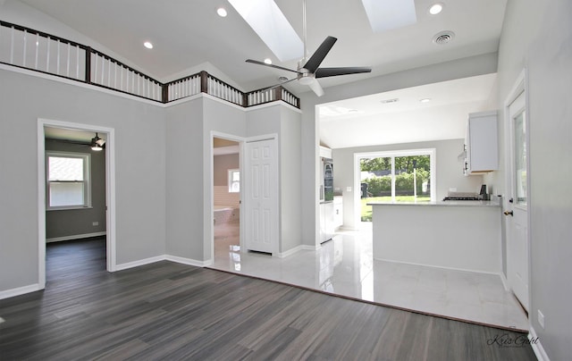 unfurnished bedroom with dark wood finished floors, baseboards, vaulted ceiling with skylight, and recessed lighting