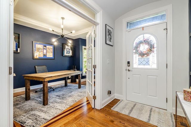 foyer with crown molding and light hardwood / wood-style floors