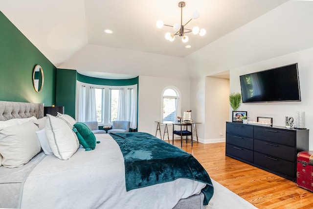 bedroom with a notable chandelier, light hardwood / wood-style flooring, and vaulted ceiling