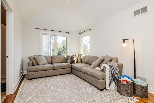 living room featuring lofted ceiling and hardwood / wood-style floors