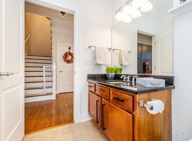 bathroom featuring tile patterned flooring, vanity, and crown molding