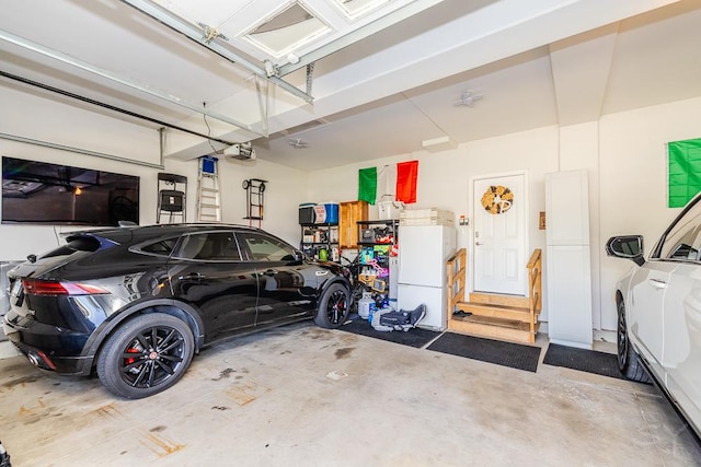 garage with a garage door opener and white fridge