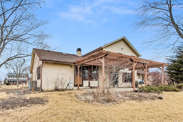 back of property with a pergola and a lawn