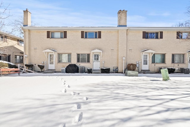 snow covered back of property with central AC unit